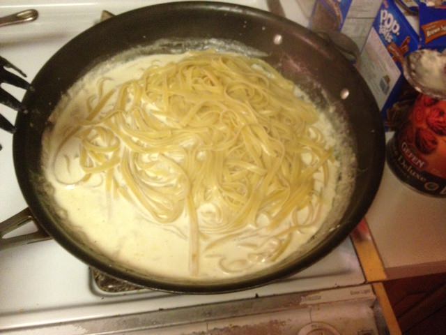 Add cooked pasta into Alfredo sauce