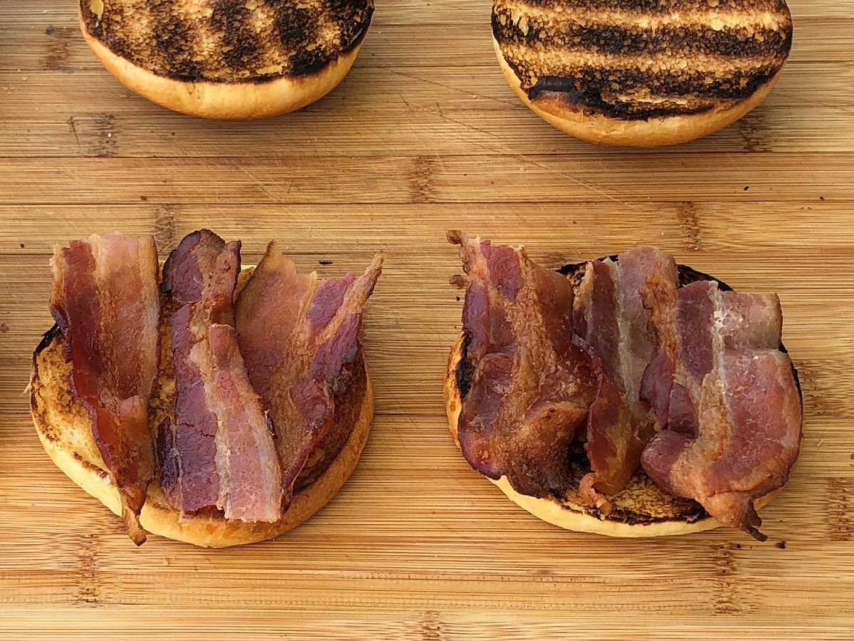 Place two slices of bacon on the bun bottoms