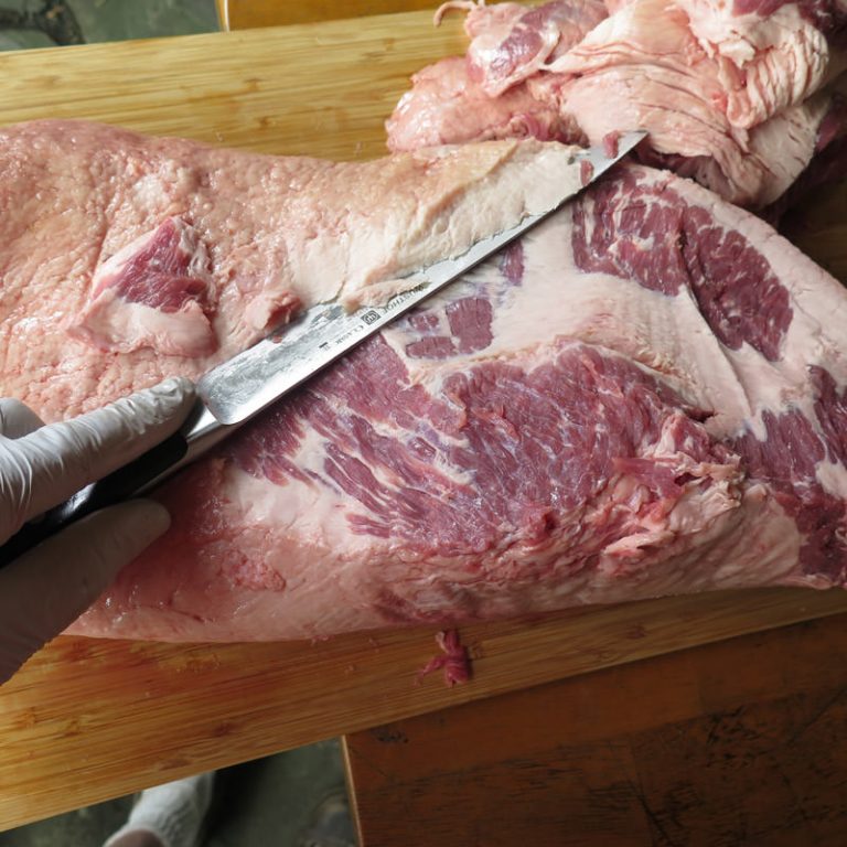 Trim fat off the point muscle (thicker half of brisket) to expose the meat, but leave all the fat on where it covers the flat