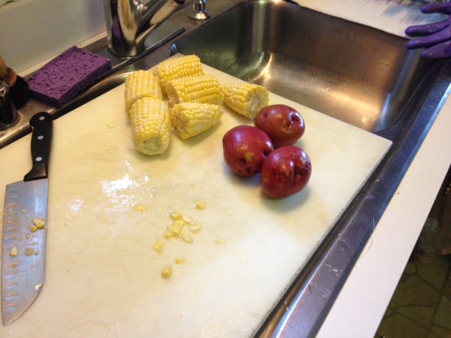 Small red potatoes par-boiled and ears of corn sectioned into thirds