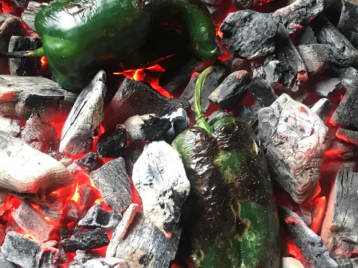 Char poblano peppers directly on charcoal