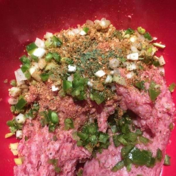 Add the white parts of green onion, jalapeño, dried cilantro, and IPA Seasoning to the pork