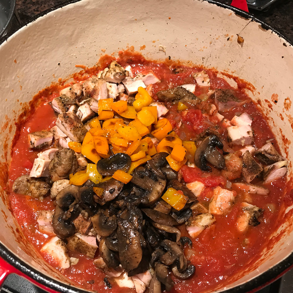 Add peppers, mushrooms and chicken to sauce, and simmer