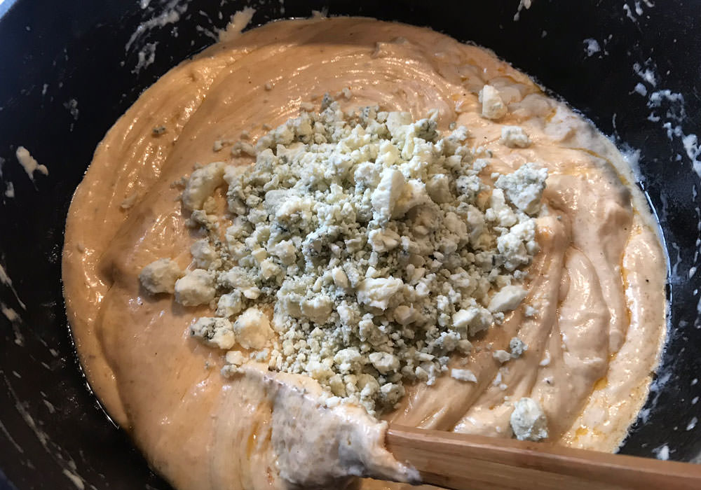Slowly add the rest of the cheese - Cheddar, Parmesan, and crumbled Gorgonzola cheese. Keep stirring until all the cheeses are melted