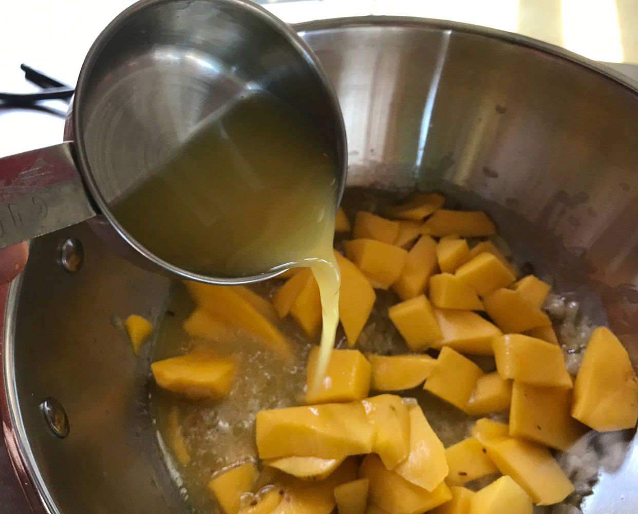 Add mango and all liquids, except for the coconut cream, to the pan