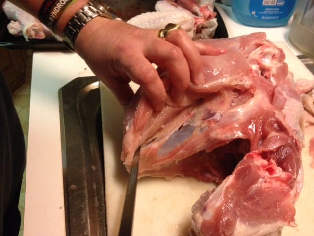 Carefully work the boning knife under the breast, separating it from the bone