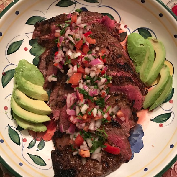 Slice flank steak and served with Pebre sauce and avocado