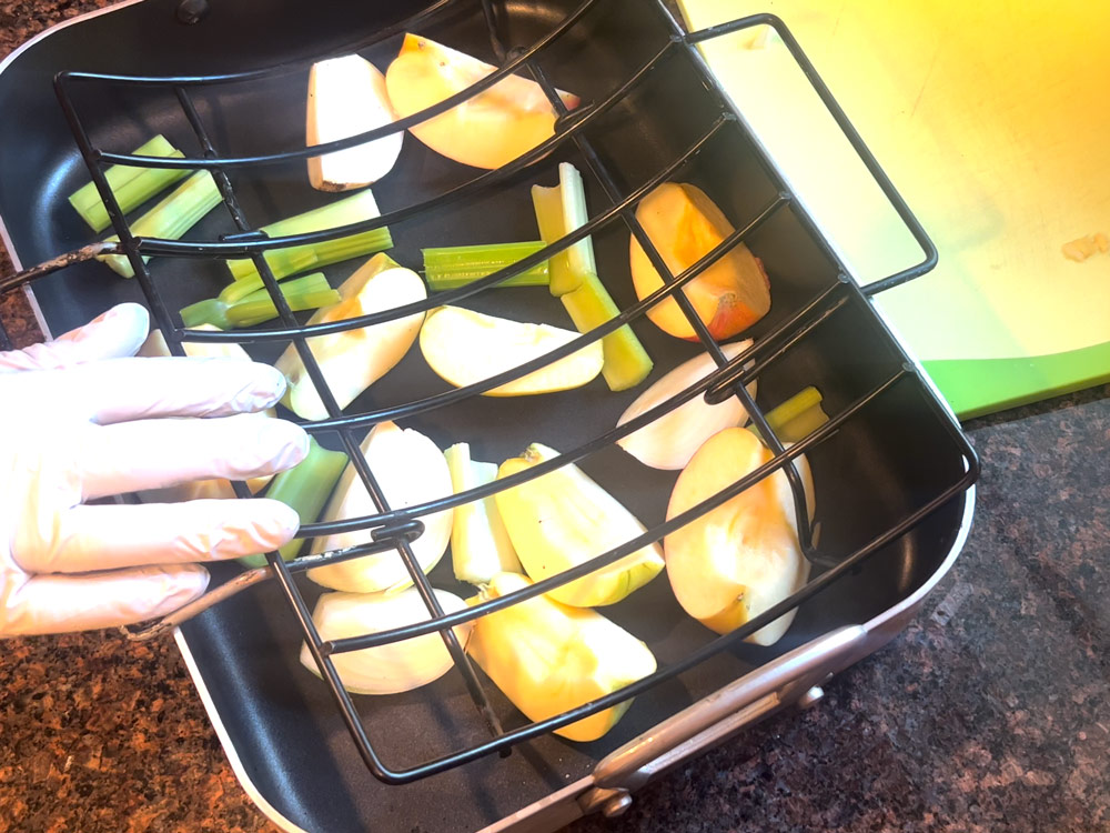 Spread out onion, celery and apples in roasting pan