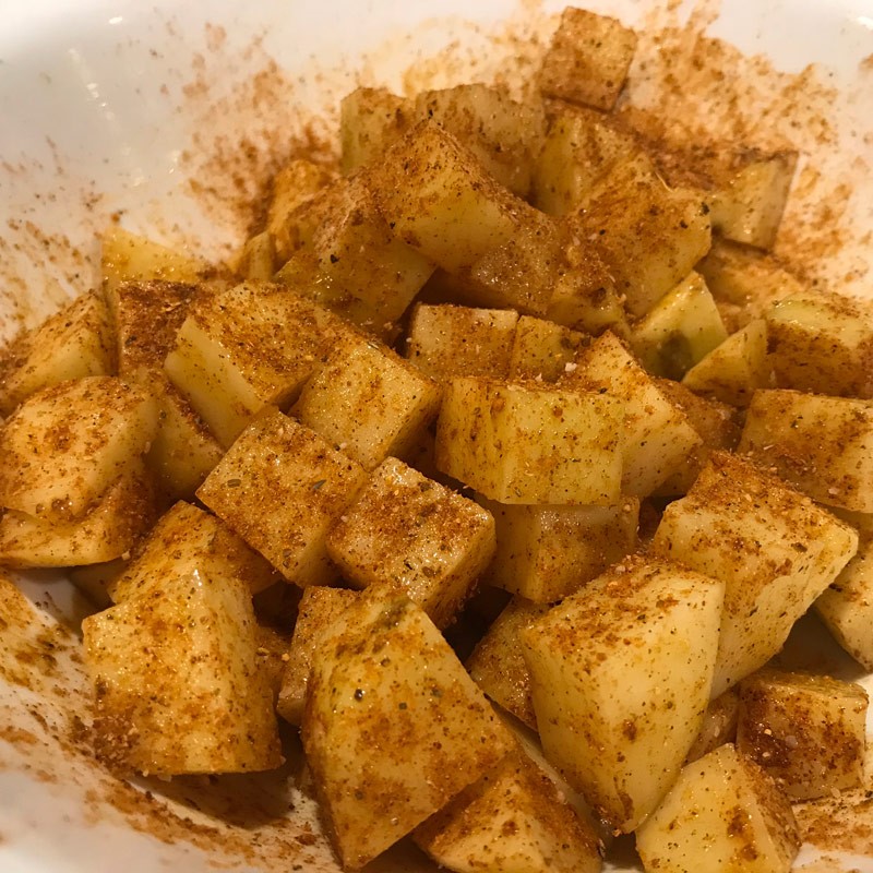 Lightly oil and season cubed potatoes