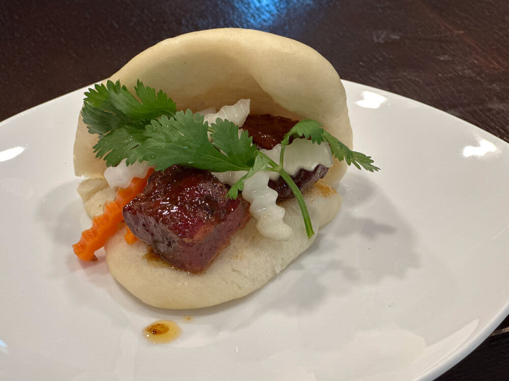 Pork belly cubes on steamed bao bun