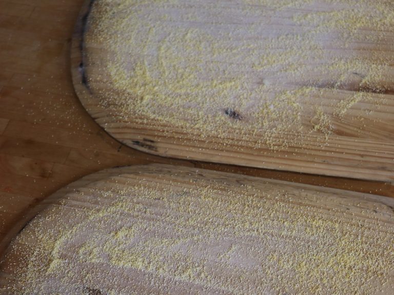 Sprinkle corn meal onto pizza peel