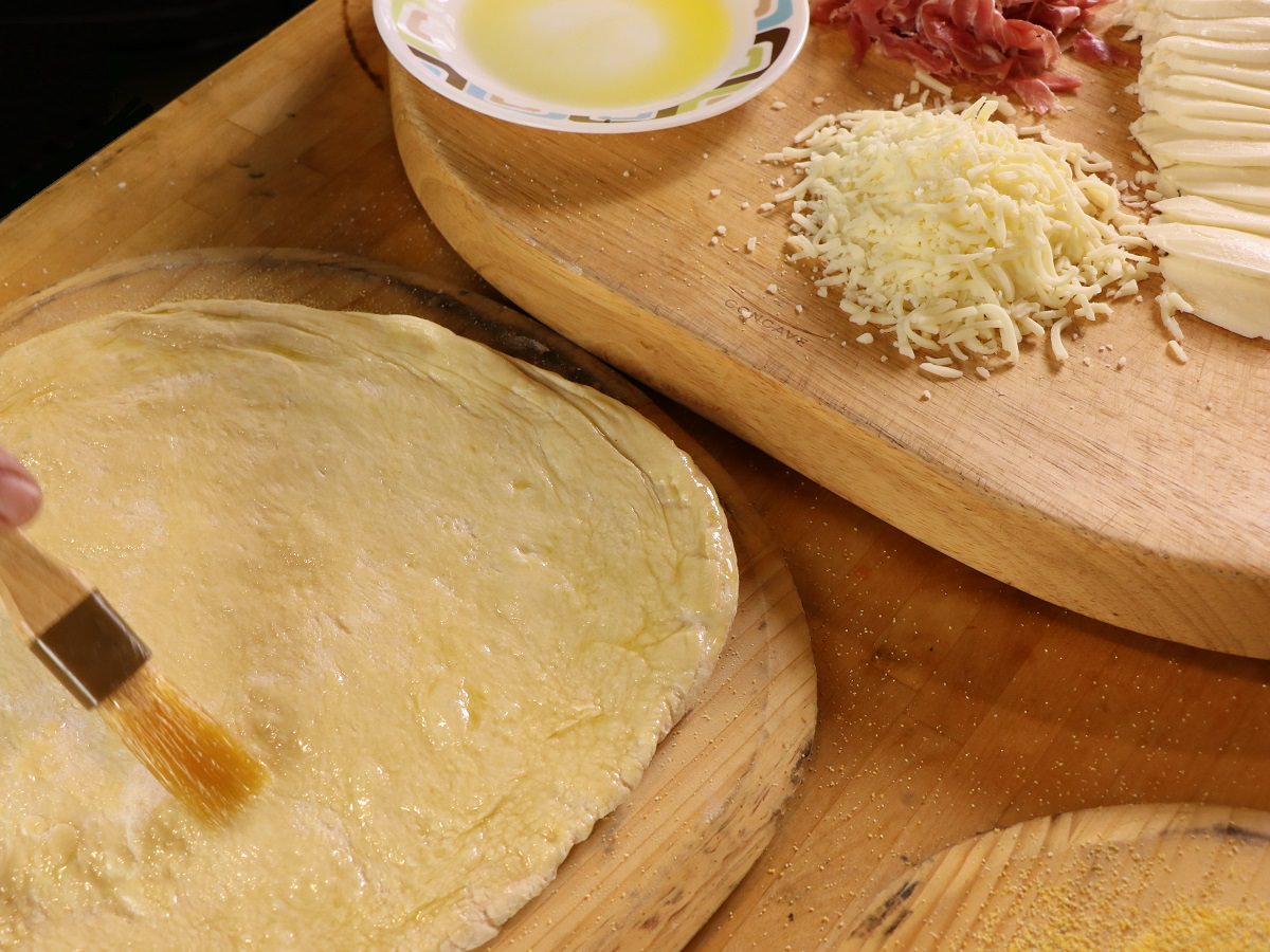 Brush the crust of the pizza with olive oil