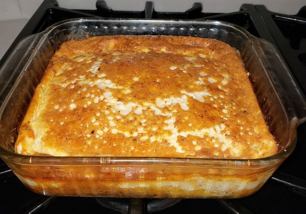 Finished corn pudding in a square 8″x8″ casserole dish.