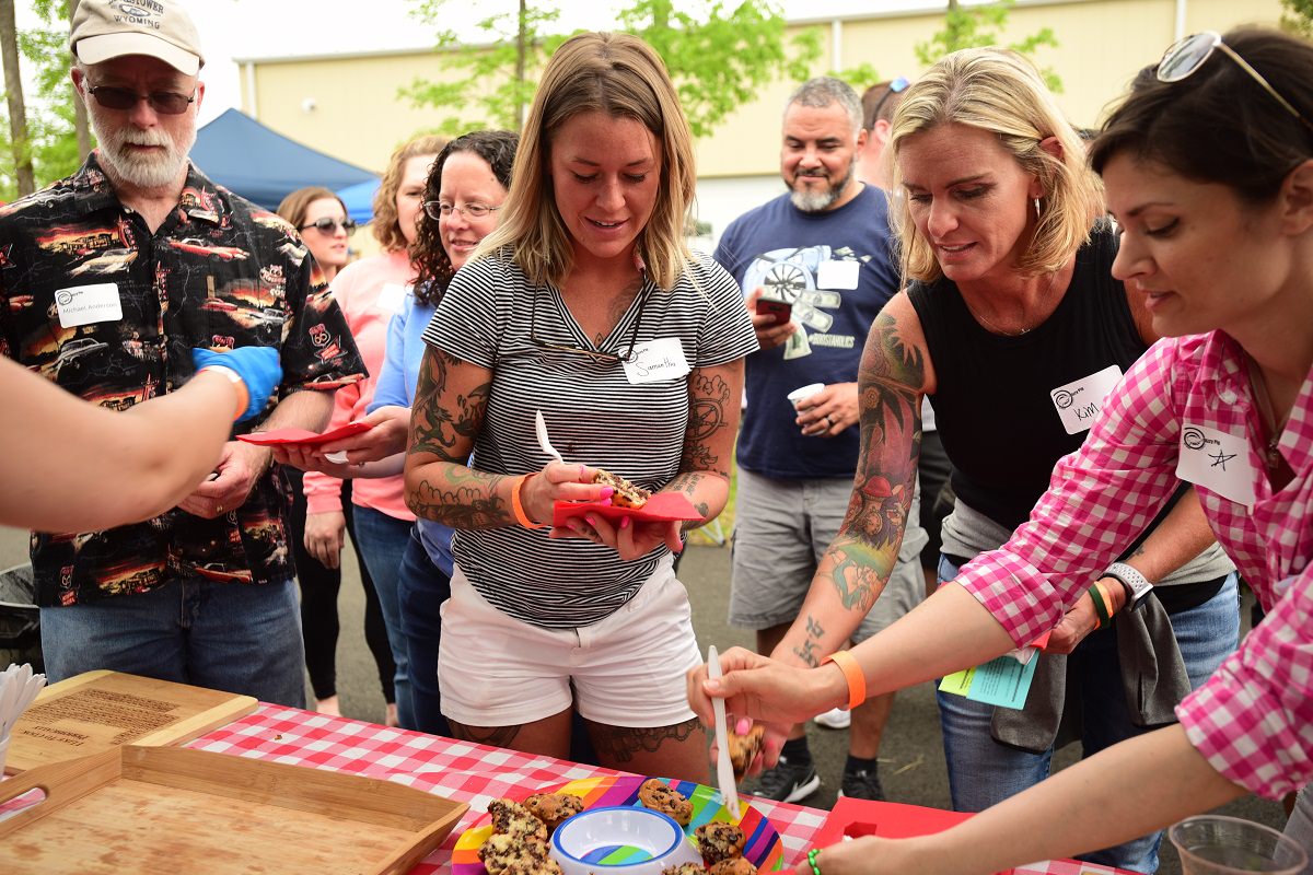 people getting muffins from a platter